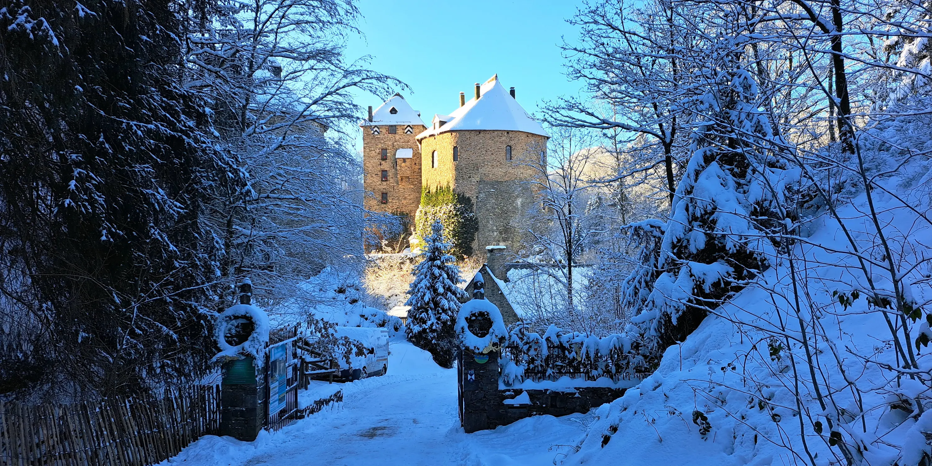 Vue du château de Reinhardstein en hiver, depuis le Nord, présentant la tour Saint-Hubert, le donjon et la tour de la Chapelle, dont la partie plus foncée en bas constitue le mur d’origine et la partie haute celle qui est reconstruite, avec en contrebas le toit de la burghaus.